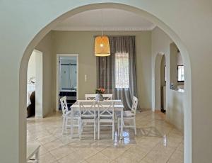a dining room with a white table and chairs at KALIMERA Suite Kalamata in Kalamata
