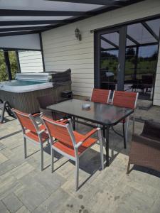 a table and chairs on a patio with a pool at Sodyba Pirtis Panarvė in Lazdijai