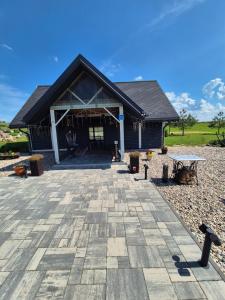 a house with a large patio in front of it at Sodyba Pirtis Panarvė in Lazdijai