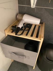 a hair dryer in a wooden holder in a drawer at Morgins, studio avec balcon in Morgins