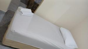 Chapéu ViradoにあるApartamento no Murubiraのベッド1台(白いシーツ、タオル2枚付)