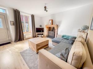 a living room with a couch and a fireplace at La Maison du Lac in La Ferté-Macé