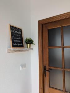 a chalkboard next to a door with a plant on it at Casa Corredera in Cumbres Mayores