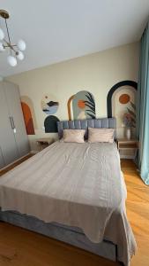 a bedroom with a bed with a painting on the wall at Herastrau Hideaway in Bucharest +17 photos