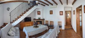 a living room with a table and a staircase at Casa Corredera in Cumbres Mayores