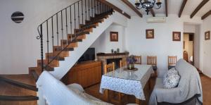 a living room with a staircase and a table and chairs at Casa Corredera in Cumbres Mayores