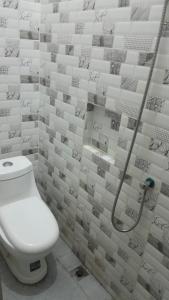 a bathroom with a toilet and a shower at Losmen cempaka in Sibengkok