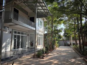 a white house with a walkway in front of it at ColYve Siem Reap in Phum Pobos
