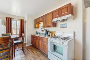 eine Küche mit Holzschränken und einem weißen Herd mit Backofen in der Unterkunft Meadow-Front Metcalf Bay Gem #542 in Big Bear Lake