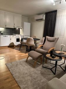 a living room with tables and chairs and a kitchen at Leiligheten in Trondalen
