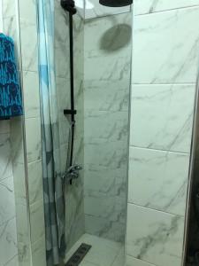 a shower in a bathroom with white marble at Appartement typique Marocain in Agadir