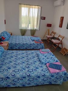 a bedroom with two beds with blue comforter at Srebrno Jezero studio apartman Dimi in Veliko Gradište