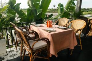 einen Tisch mit einem rosa Tischtuch auf einer Terrasse in der Unterkunft Pomelo Outpost Cambodia ដំណាក់ភ្នំក្រោម in Phumĭ Rœssei Lŭk