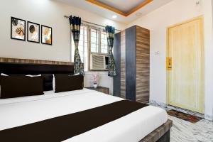 a bedroom with a large bed and a window at Hotel O S. R. ROYALE in Kolkata +21 photos