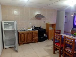 a kitchen with a stove and a refrigerator and a table at FORTIN HOUSE in Malargüe