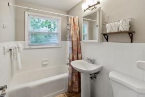 a white bathroom with a sink and a tub and a mirror at Pet Friendly Near Anna Maria And Img in Bradenton +40 photos