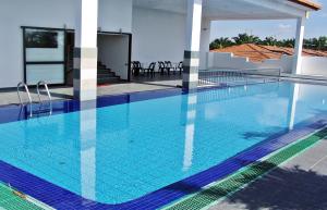 een zwembad met blauw water in een gebouw bij Sun Inns Hotel Sitiawan in Sitiawan