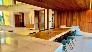 ein Konferenzraum mit einem großen Holztisch und Stühlen in der Unterkunft Mansão Pé na Areia 8 Suítes Alphaville Guarajuba in Barra de Jacuípe