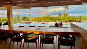 eine Bar mit Stühlen und Meerblick in der Unterkunft Mansão Pé na Areia 8 Suítes Alphaville Guarajuba in Barra de Jacuípe