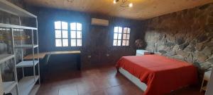 クルス・デル・エヘにあるEl cuarzo Casa de Monte y Retiroのベッドと石の壁のある寝室