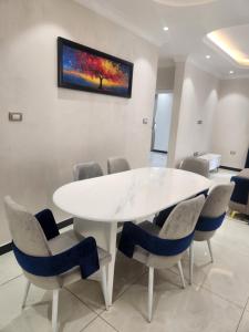 a white table and chairs with a painting on the wall at Majestic Dream living in Addis Ababa