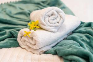 a towel with a flower on it on a bed at Cozy Ground Floor Getaway Stylish & Central 1BR in Canterbury +35 photos