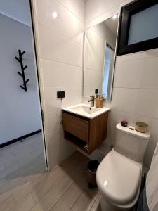 un bagno con un water bianco e un lavandino di Departamento estudio con terraza vista al mar a Valparaíso