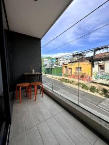 un balcone con tavolo, 2 sedie e finestra di Departamento estudio con terraza vista al mar a Valparaíso