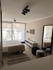 una camera da letto con un letto e un grande specchio di Departamento estudio con terraza vista al mar a Valparaíso Altre 3 foto