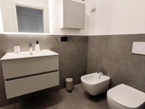 シルミオーネにあるCasa Joma - luxury apartmentの白い洗面台とトイレのあるバスルーム +15枚の写真