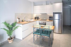 a kitchen with a table and a stainless steel refrigerator at Μilia Olive&Terra Apatments in Kynopiástai +5 photos