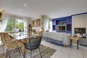 a living room with a table and chairs and a couch at Cap Mango Paradise in Capbreton