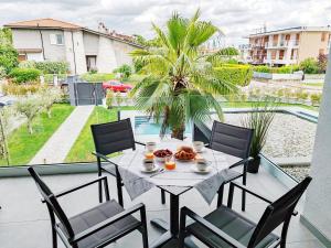 シルミオーネにあるCasa Joma - luxury apartmentのプールを望むバルコニー(テーブル、椅子付)