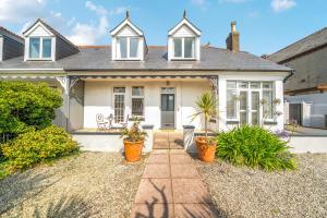 a white house with potted plants in front of it at Palm House in Newquay