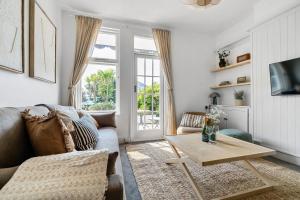 a living room with a couch and a table at Palm House in Newquay