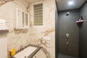 un baño con lavabo y ducha en Flyora Studio 5min to Airport, en Pune