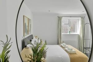 a bedroom with a bed and a mirror at Palm House in Newquay