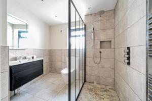 a bathroom with a shower and a toilet and a sink at Palm House in Newquay +38 photos