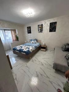 a bedroom with a king sized bed and a marble floor at Apartament IRI Băile Herculane in Băile Herculane