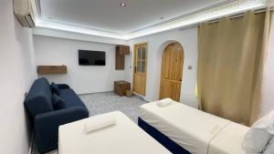 a living room with a blue couch and a tv at Dar Chefchaouen in Chefchaouen