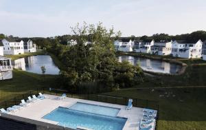 an aerial view of a swimming pool with houses and a river at 5br Beauty Near Bethany-community Pool Linens in Ocean View