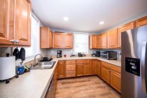 a kitchen with wooden cabinets and a stainless steel refrigerator at Charming Havre de Grace Home Walk to Downtown in Havre de Grace