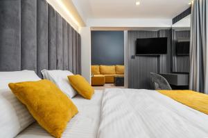 Cette chambre d'hôtel dispose d'un lit avec des oreillers jaunes. dans l'établissement Sokak Heritage Apartments, à Bitola