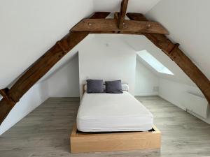 a bedroom with a bed in the attic at La Basse Meule Maison in Juvigné