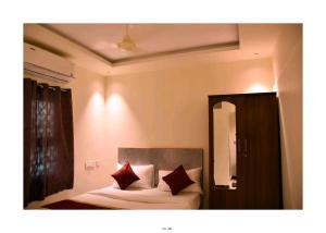 a bedroom with a bed with two red pillows at GK Luxury Stay in Tiruchchirāppalli
