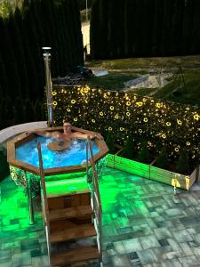 a man in a jacuzzi tub in a backyard at Zagrodek Premium Spa in Gródek Nad Dunajcem