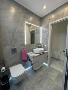 a bathroom with a sink and a toilet and a mirror at Modern 2 bedroom Townhouse in Paphos City