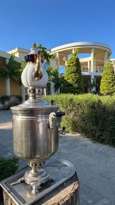 a fire hydrant sitting on a stump in front of a house at Village Taste Guest House in Buzovna