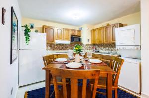 a kitchen with a wooden table with chairs and a white refrigerator at Ocean Sol in Old SanJuan by PH in San Juan +20 photos