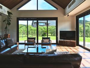 a living room with a couch and a tv at Cairns House by SANA in Tateyama